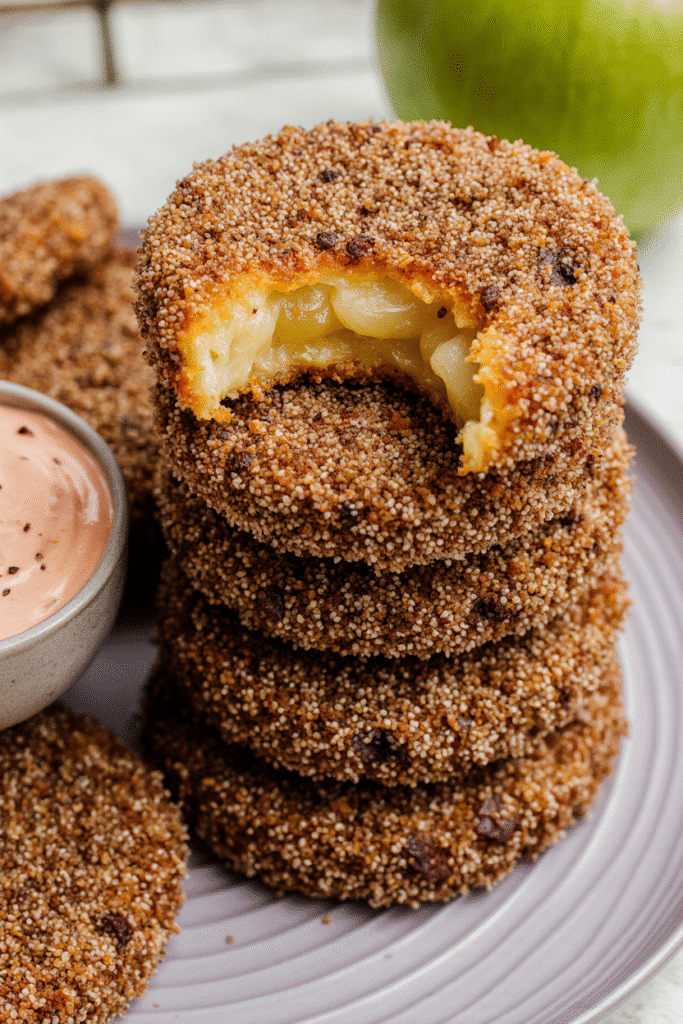 Flat lay of raw ingredients for fried green tomatoes: sliced green tomatoes, bowls for dredging, and spices.