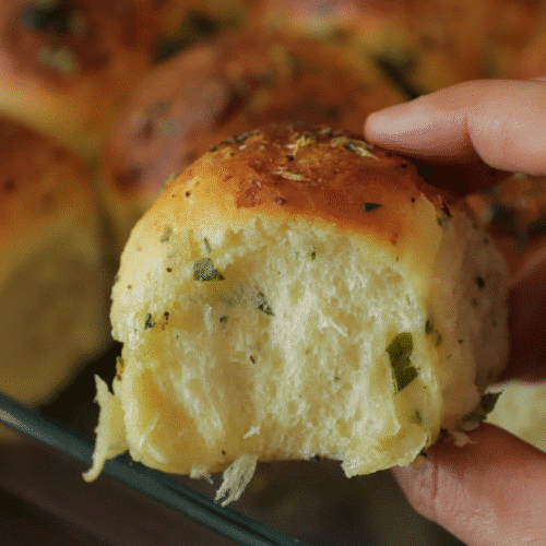 A basket of freshly baked 30-Minute Garlic Parmesan Dinner Rolls topped with melted butter and herbs, recipe card