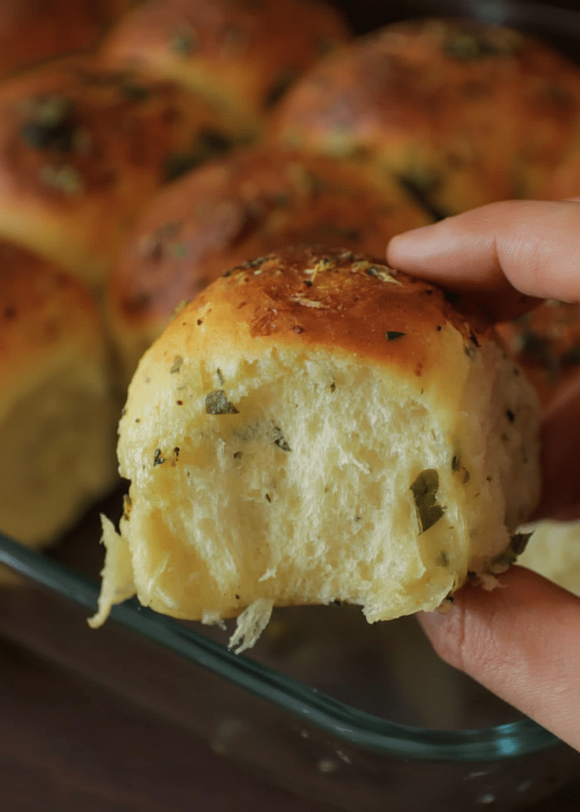 A basket of freshly baked 30-Minute Garlic Parmesan Dinner Rolls topped with melted butter and herbs, recipe card