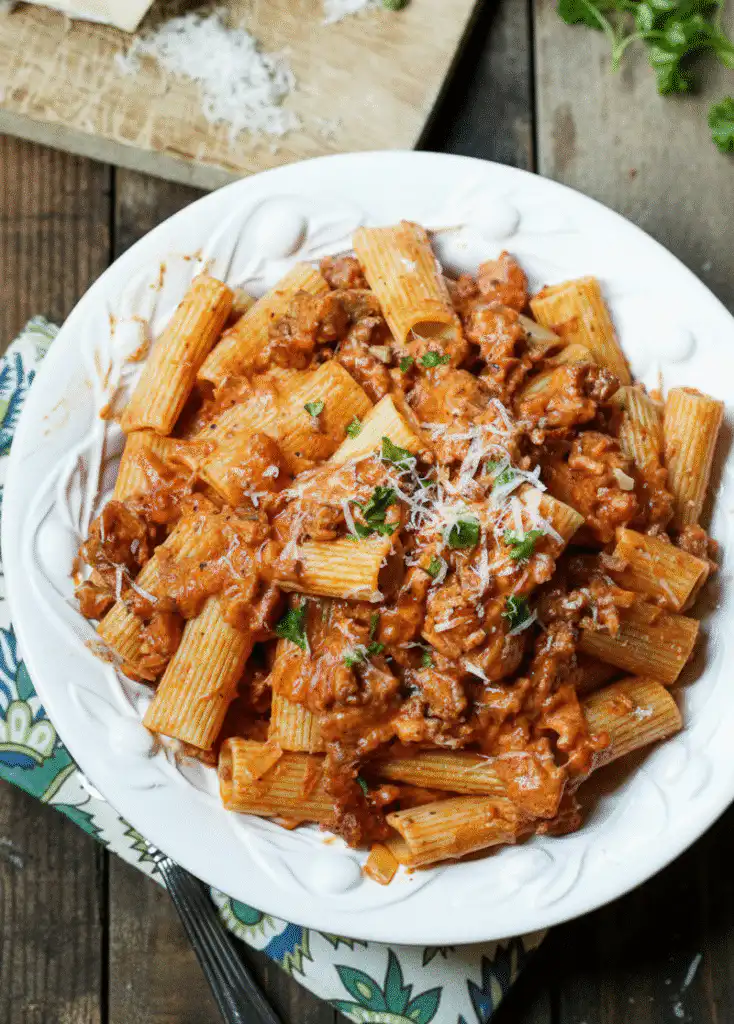 Creamy tomato garlic pasta dish garnished with fresh herbs serving