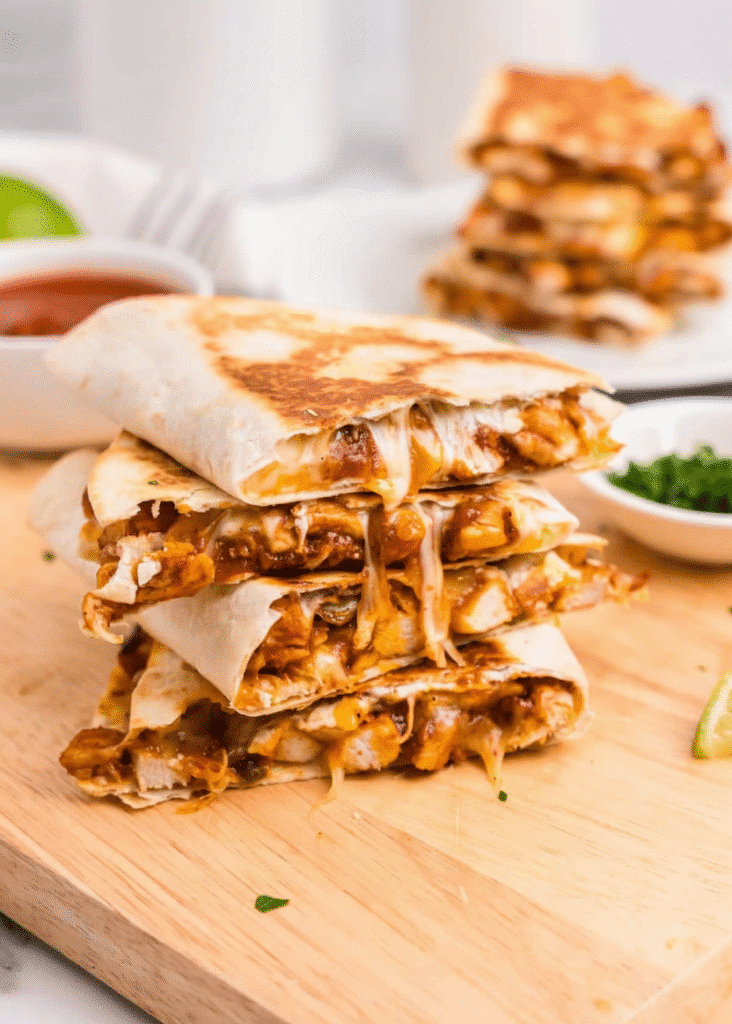 Delicious BBQ Chicken Quesadillas served with salsa and garnished with herbs serving