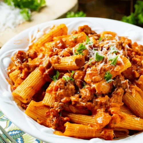 Creamy tomato garlic pasta dish garnished with fresh herbs recipe card