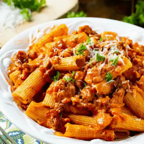Creamy tomato garlic pasta dish garnished with fresh herbs recipe card