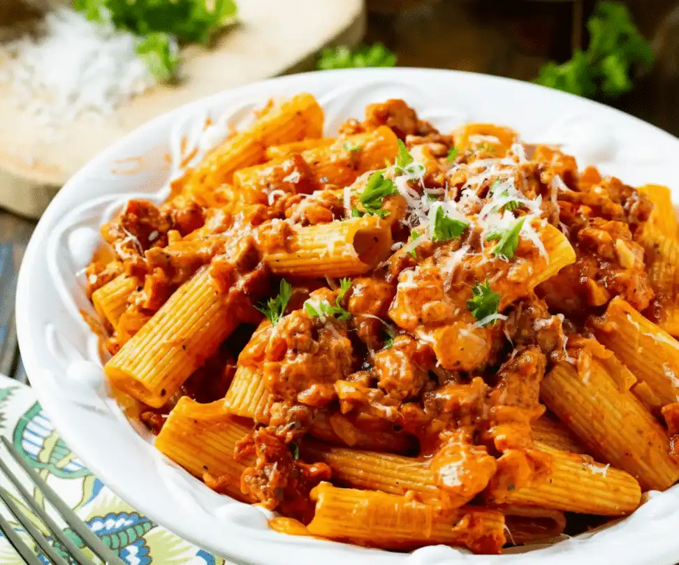 Creamy tomato garlic pasta dish garnished with fresh herbs recipe card