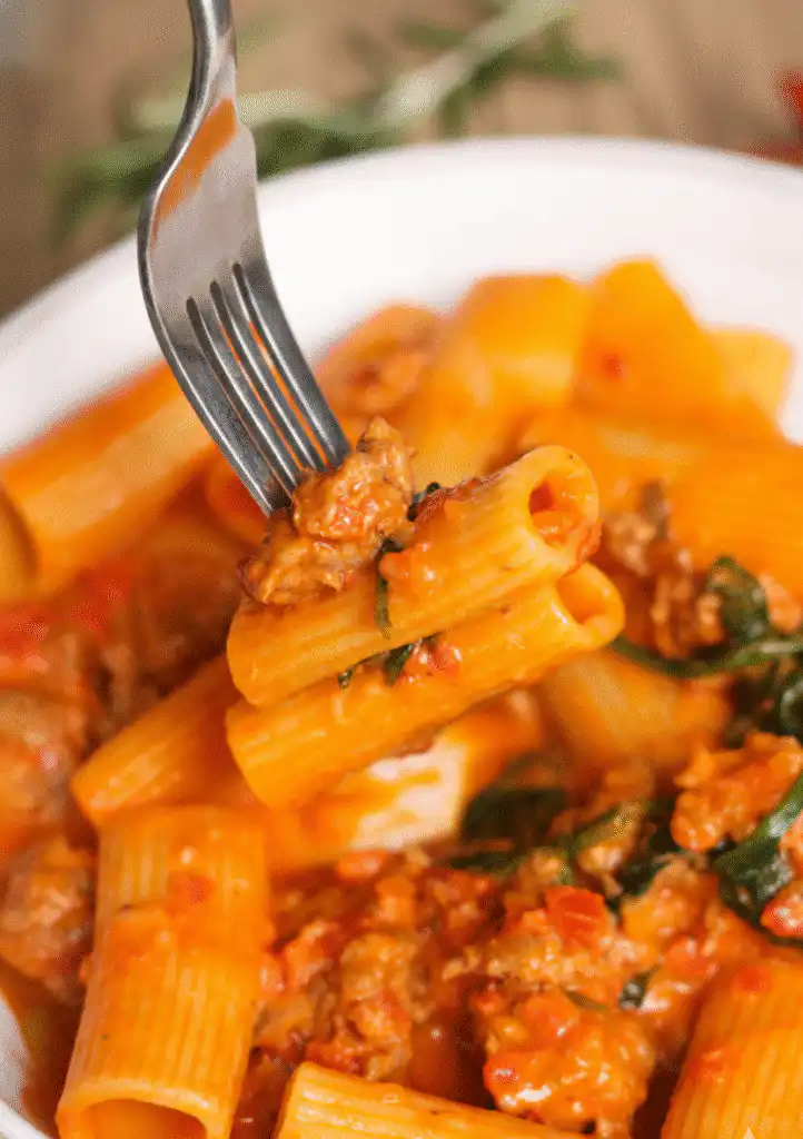 Creamy Italian Sausage Rigatoni dish garnished with fresh herbs