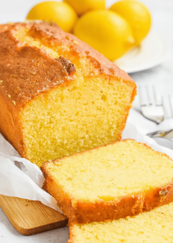 Deliciously moist lemon cake decorated with fresh lemon slices and icing serving