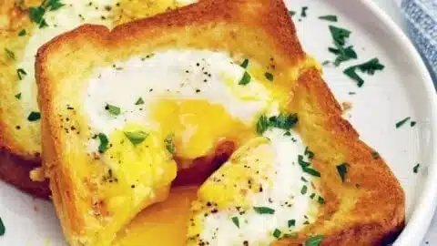 Delicious Air Fryer Egg Toast topped with fresh herbs and served on a plate