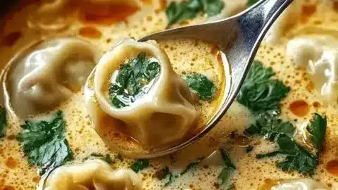 Bowl of comforting Thai potsticker soup with herbs and potstickers