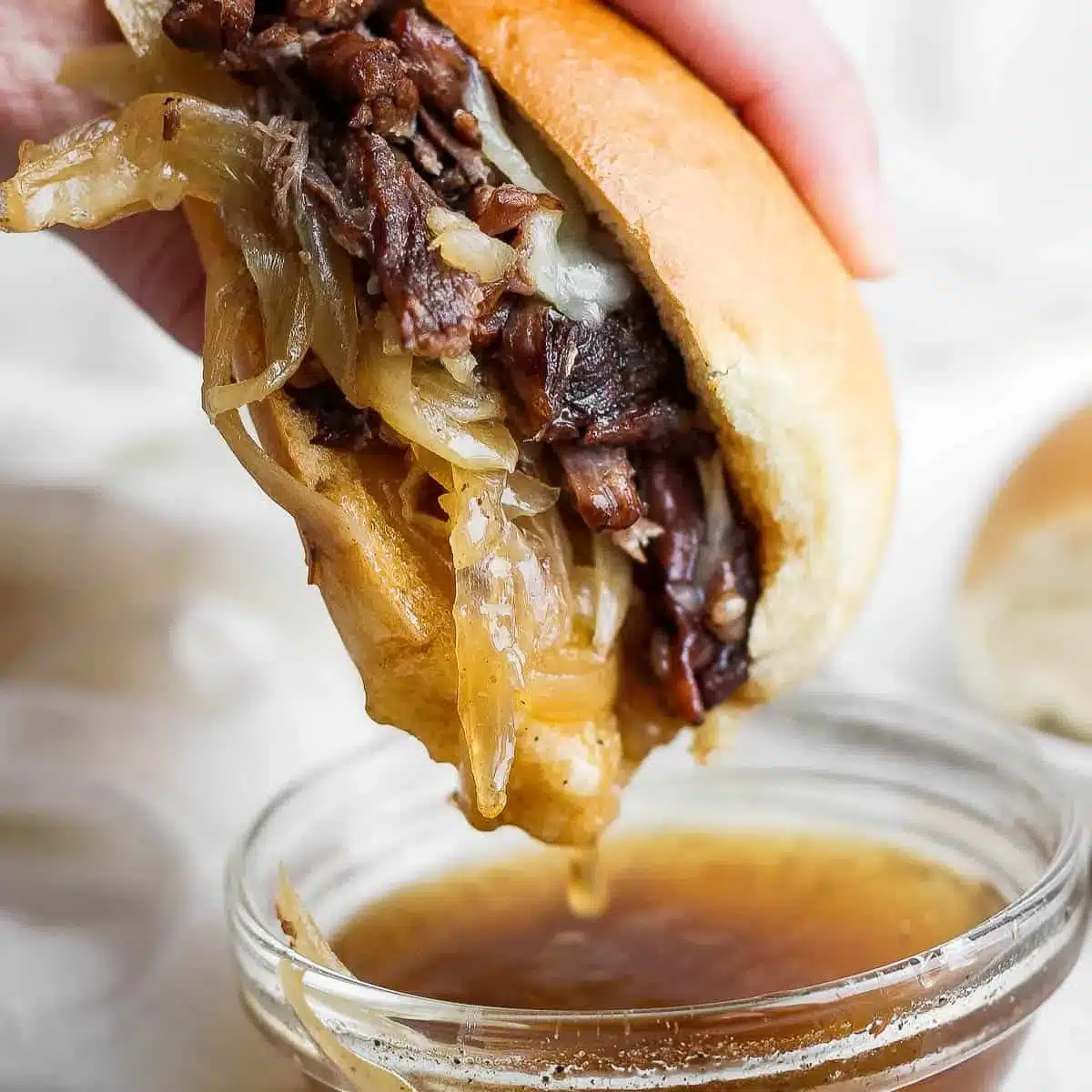 Homemade French Dip Sandwiches with beef, melted cheese, and dipping sauce