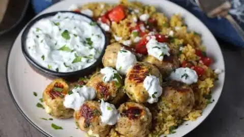 Greek Chicken Meatballs with Tzatziki Sauce 2 Plate of Greek chicken meatballs with tzatziki sauce garnished with herbs