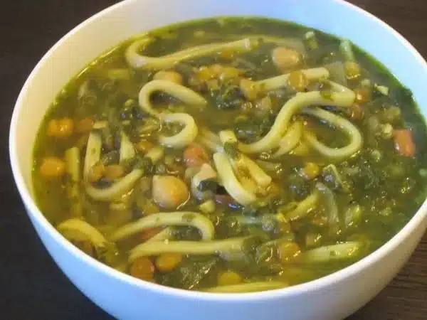Ash Reshteh translates to "Noodle Soup" in English. 2 Bowl of Ash Reshteh, a traditional Iranian noodle soup with herbs and legumes.