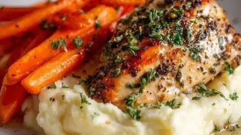 Delicious Garlic Herb Chicken with mashed potatoes and glazed carrots on a plate
