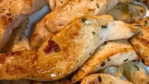 Plate of Greek Chicken Tenders garnished with herbs and lemon slices