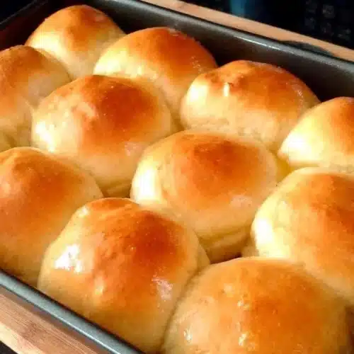 Sweet Dinner Rolls 2 Homemade sweet dinner rolls displayed on a rustic wooden table.