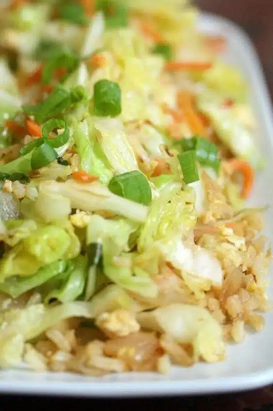 Bowl of colorful cabbage fried rice with vegetables and herbs