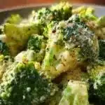 Creamy Garlic Parmesan Broccoli in a bowl garnished with herbs