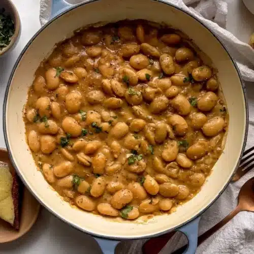Bowl of French onion butter beans garnished with herbs