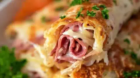 Keto Crispy Reuben Roll-Ups served on a plate, garnished with herbs.