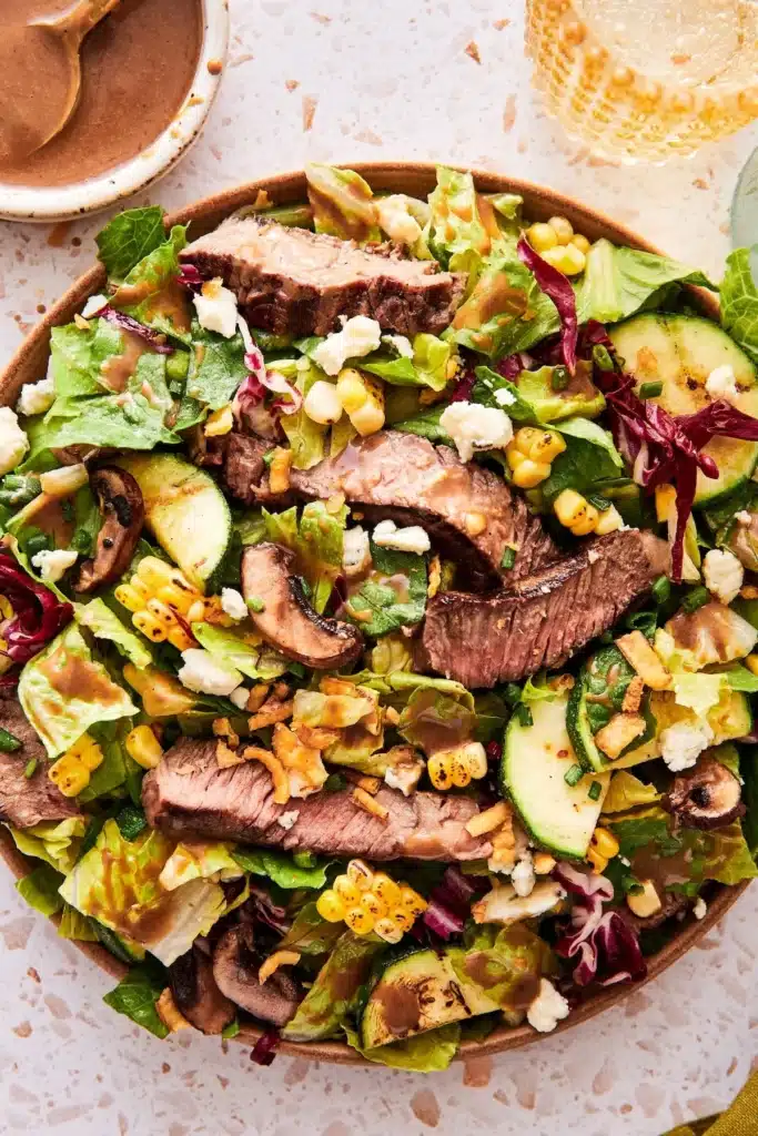 Delicious grilled steak salad with fresh vegetables and dressing