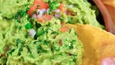 A bowl of delicious homemade guacamole with fresh ingredients.