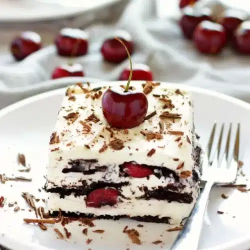 No Bake Black Forest Icebox Cake topped with cherries and whipped cream.