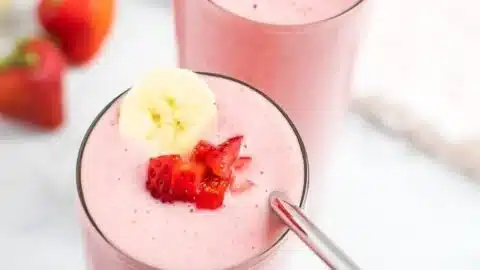 Delicious strawberry banana smoothie in a glass with fresh fruit