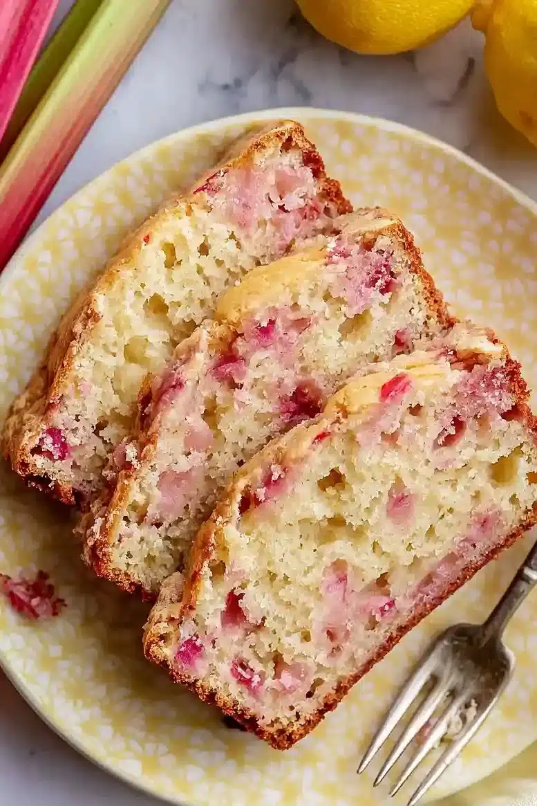Loaf of delicious lemon rhubarb bread with slices on a wooden table
