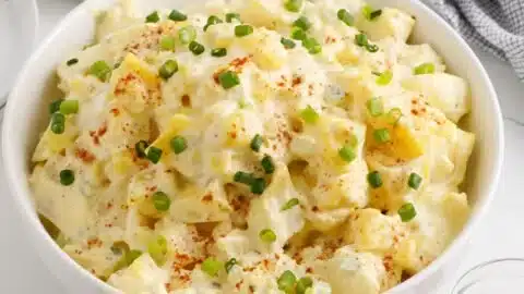 Potato Salad Recipe 2 Freshly made potato salad served in a bowl with herbs and colorful vegetables.